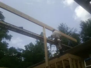 Carpenter setting a ridge beam over a new addition frame — Ice Dam Removal by Roofing Brothers in Queen Anne