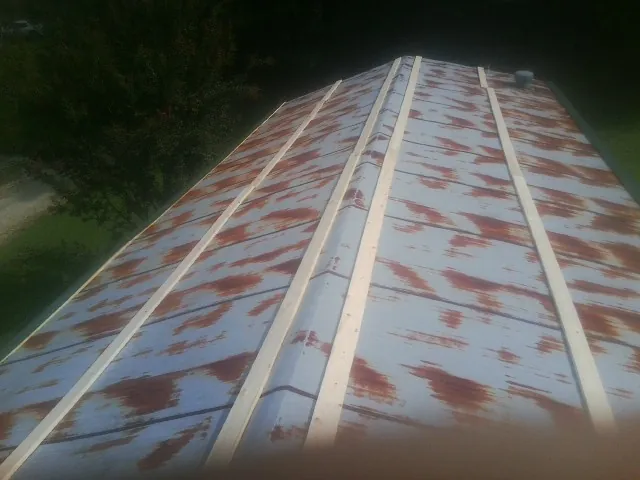 Rusted metal roof panels with new wood purlins before replacement — Storm Damage Roof Repair in Queen Anne by Roofing Brothers