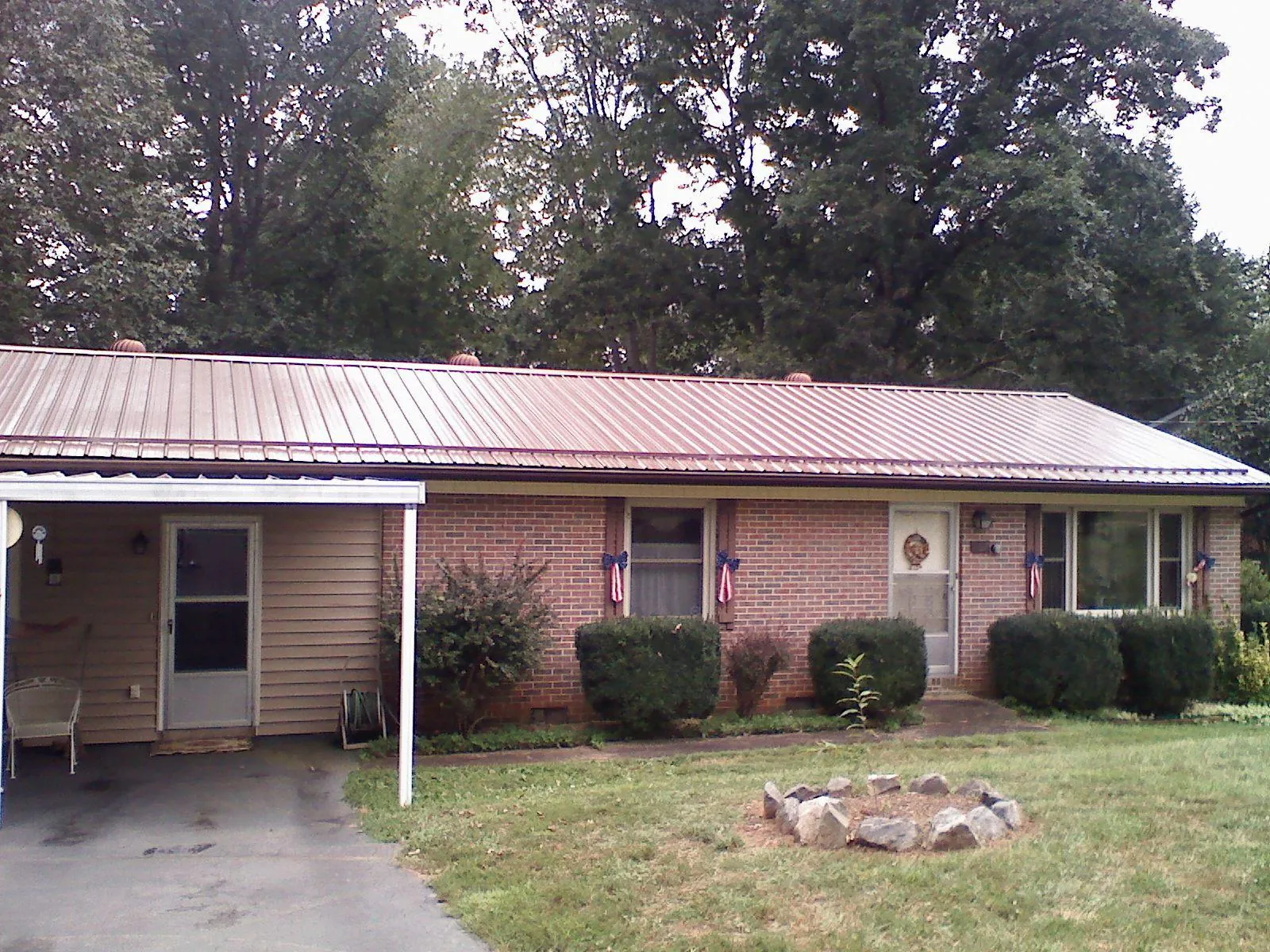 Bronze metal roof and carport on a brick ranch home — Roof Repair work by our crew in Queen Anne